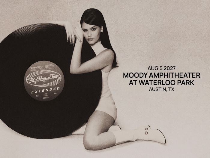 Sienna Spiro leaning on a giant vinyl record for her My House Tour concert at Moody Amphitheater in Austin, TX.
